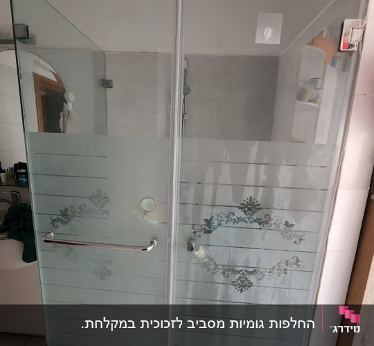 מקלחון זכוכית עם דלתות פתיחה על צירים וצריבת חול דקורטיבית